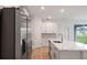 Modern kitchen featuring stainless steel appliances, a large island, and white cabinets with plenty of storage at 6929 Sw 130Th Lane Rd, Ocala, FL 34473
