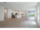 Open-concept living area with modern flooring, a kitchen island, and sliding glass doors to the backyard at 6929 Sw 130Th Lane Rd, Ocala, FL 34473