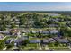 Expansive aerial view showcasing a neighborhood with mature trees and a scenic lake in the distance at 7033 Lakner Way, Orlando, FL 32822