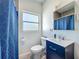Updated bathroom with blue vanity, new mirror, and updated toilet and shower at 7033 Lakner Way, Orlando, FL 32822