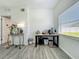 Bright flex room with grey wood-look flooring, neutral walls, and well-lit by the window at 7033 Lakner Way, Orlando, FL 32822