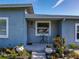 Inviting front porch with tiled floor, stylish plants, and outdoor furniture at 7033 Lakner Way, Orlando, FL 32822