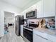 Kitchen featuring stainless steel appliances, microwave, and white cabinets at 7033 Lakner Way, Orlando, FL 32822