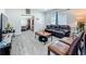 Modern living room with grey wood-look flooring, neutral walls, and comfortable leather seating at 7033 Lakner Way, Orlando, FL 32822