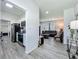 View of the living room, from the kitchen, showcasing the grey wood-look flooring and comfortable leather seating at 7033 Lakner Way, Orlando, FL 32822