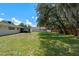 Spacious backyard with healthy grass, an outbuilding, and an attached screened-in porch at 7360 Canal Dr, Sanford, FL 32771