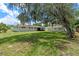 Expansive backyard featuring mature trees, lush grass, and a charming home exterior with a screened-in porch at 7360 Canal Dr, Sanford, FL 32771