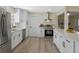 Stylish kitchen with white cabinets, stainless steel appliances, and wood flooring at 7360 Canal Dr, Sanford, FL 32771