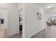 Bright hallway with wood floors leading to bedrooms, bathrooms, and living room at 756 Rioja Dr, Minneola, FL 34715