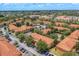 Aerial shot of a community showcasing residential buildings, lush trees, parking areas, and community pool at 7625 Long Island Dr, Kissimmee, FL 34747