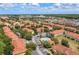 A panoramic view of the residential community showcasing terracotta rooftops, lush landscaping, and scenic cityscape in the distance at 7625 Long Island Dr, Kissimmee, FL 34747