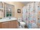 Bathroom featuring a single sink vanity, toilet, and a shower with a decorative ocean themed curtain at 7625 Long Island Dr, Kissimmee, FL 34747