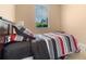Comfortable bedroom featuring colorful striped bedding and natural light streaming through a window at 7625 Long Island Dr, Kissimmee, FL 34747