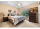 Inviting bedroom with neutral decor, bedside tables, and a large window overlooking a lush green view at 7625 Long Island Dr, Kissimmee, FL 34747