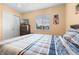 Bedroom showcasing a closet, TV on a dresser, and a large window overlooking the neighborhood at 7625 Long Island Dr, Kissimmee, FL 34747