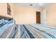 Bedroom with a striped blue and white bedspread and an open doorway at 7625 Long Island Dr, Kissimmee, FL 34747