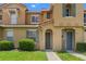 Charming townhome with a terra cotta roof, green shutters, and well-manicured landscaping at 7625 Long Island Dr, Kissimmee, FL 34747