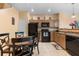 Cozy kitchen with tile floors, wood cabinets, and black appliances adjacent to dining area at 7625 Long Island Dr, Kissimmee, FL 34747