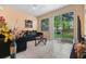 Inviting living room featuring tile flooring, backyard views, and access to the patio at 7625 Long Island Dr, Kissimmee, FL 34747