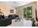 Relaxing living room with tile flooring, sliding glass doors, and a modern ceiling fan at 7625 Long Island Dr, Kissimmee, FL 34747