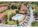Aerial view of a community pool and cabana area nestled among residences, parking lots, and manicured green spaces at 7625 Long Island Dr, Kissimmee, FL 34747