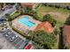 Aerial view of a community pool with lounge chairs and well-maintained landscaping surrounded by residences and parking area at 7625 Long Island Dr, Kissimmee, FL 34747