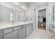 Spacious bathroom featuring double vanity, walk-in shower, and a doorway to a walk-in closet at 7778 Four Seasons Blvd, Kissimmee, FL 34747