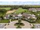Aerial view of the community clubhouse with manicured landscaping, a circular driveway, and a golf course nearby at 7778 Four Seasons Blvd, Kissimmee, FL 34747