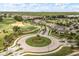 Aerial view of the manicured community entrance with a roundabout, showcasing golf course and landscaping at 7778 Four Seasons Blvd, Kissimmee, FL 34747