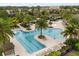 An aerial shot shows a community pool area with palm trees, lounge chairs, and plenty of space to relax at 7778 Four Seasons Blvd, Kissimmee, FL 34747