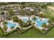 Aerial view of a resort-style community pool with palm trees, lounge chairs, and manicured landscaping at 7778 Four Seasons Blvd, Kissimmee, FL 34747