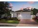 Charming single-story home with a brick driveway and a two-car garage at 7778 Four Seasons Blvd, Kissimmee, FL 34747