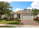 Charming one-story home boasts a pristine lawn, inviting walkway, and an attached two-car garage at 7778 Four Seasons Blvd, Kissimmee, FL 34747