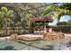 Relax in this screened pool area featuring a tiki bar, grill, and captivating rock waterfall at 7778 Four Seasons Blvd, Kissimmee, FL 34747