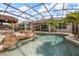 Screen enclosed pool with palm trees, tiki bar, tanning ledge, and clear blue water at 7778 Four Seasons Blvd, Kissimmee, FL 34747