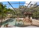 This screened pool offers lush landscaping, a tiki bar, and tranquil rock waterfall features at 7778 Four Seasons Blvd, Kissimmee, FL 34747