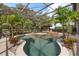 Enclosed pool with palm trees, tiki bar, and clear blue water surrounded by decorative rocks at 7778 Four Seasons Blvd, Kissimmee, FL 34747