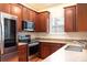 Kitchen with wood cabinets, stainless steel appliances, and granite countertops at 820 Ellwood Ave # A, Orlando, FL 32804