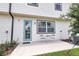 Cozy back patio with blue door, a small table with chairs, and a nice view of the green backyard at 832 Longboat Dr, Davenport, FL 33896