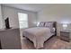 Neutral bedroom featuring soft carpet, dresser, side tables, and a queen bed with patterned bedding at 832 Longboat Dr, Davenport, FL 33896
