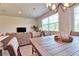 Open-concept dining area with wood table, chandelier, and large windows offering natural light and views at 832 Longboat Dr, Davenport, FL 33896