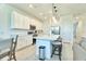 Open kitchen featuring white cabinets, stainless steel appliances, island seating, and stylish pendant lighting at 832 Longboat Dr, Davenport, FL 33896