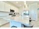 Bright kitchen with large island, white cabinets, stainless appliances, and modern pendant lighting at 832 Longboat Dr, Davenport, FL 33896