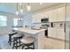 Open concept kitchen island with seating, white cabinets, stainless appliances, and dining area at 832 Longboat Dr, Davenport, FL 33896