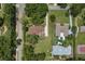 Expansive aerial view of a neighborhood with lush green lawns, mature trees, and a home featuring a pool and basketball court at 9601 Ambleside Dr, Windermere, FL 34786