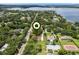 Scenic aerial view showcasing a neighborhood with tree-lined streets and a glimpse of a beautiful lake in the background at 9601 Ambleside Dr, Windermere, FL 34786