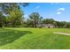 Spacious backyard with lush grass, mature trees and house in the background at 9601 Ambleside Dr, Windermere, FL 34786