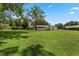 Wide angle view of backyard with large lawn, mature trees, and home in the distance at 9601 Ambleside Dr, Windermere, FL 34786