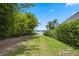 A grass path leads to a backyard with a lake view and a private and serene retreat at 9601 Ambleside Dr, Windermere, FL 34786