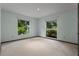 A quaint bedroom features carpeted floors and two windows to the outside at 9601 Ambleside Dr, Windermere, FL 34786